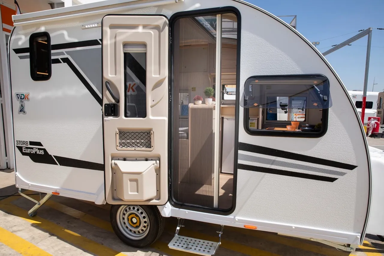 Caravana compacta VDK A370 vista lateral con la puerta abierta y mosquitera
