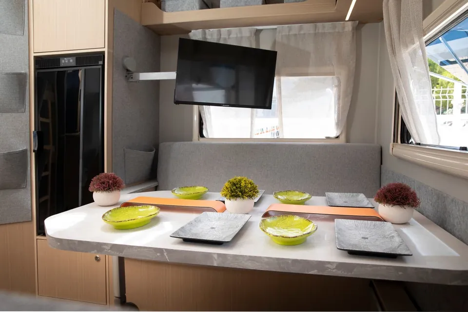 Comedor de la VDK V400L con la mesa puesta y televisor con soporte