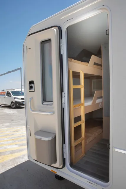 Puerta de la VDK V400L abierta, con las literas y su escalera al fondo